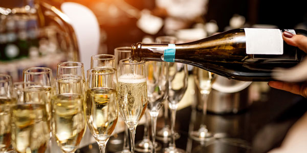 Waiter Filling A Glass Of Champagne In A Restaurant.