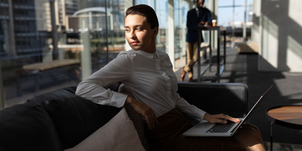 Businesswoman With Laptop Sitting On The Sofa And Looking Away I