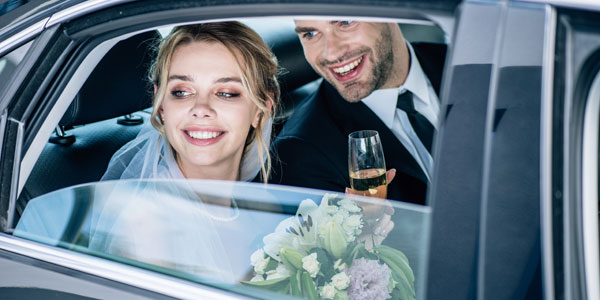 Attractive Bride And Handsome Bridegroom Clinking With Champagne Glasses